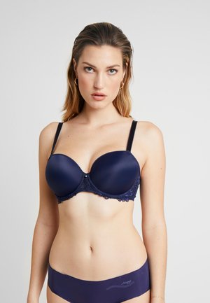 Sutiã azul marinho acolchoado com detalhes em renda, suporte com aro e alças ajustáveis. Tecido liso com um brilho sutil e accents decorativos.