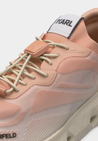Ροζ και μπεζ αθλητικό παπούτσι με ελαστικά κορδόνια και ετικέτα με το λογότυπο "KARL" στη γλώσσα, που διαθέτει παχιά υφασμένη σόλα.