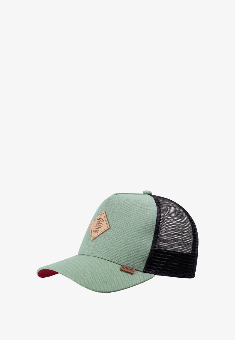 Gorra de béisbol verde con malla negra en la parte posterior, parche de logo marrón en el frontal y pequeña etiqueta marrón en el borde de la visera.