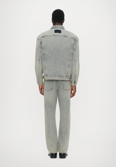 Light blue denim jacket and matching pants with a relaxed fit, featuring subtle embellishments and a classic collar design.