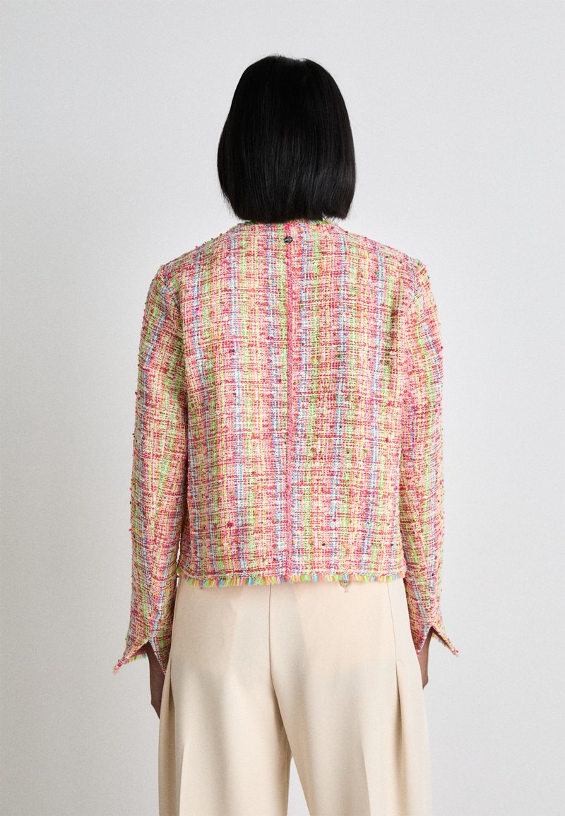 Rosa und mehrfarbiger Tweedjacke mit fransengesäumtem Saum, langen Ärmeln und einer Knopfleiste auf der Rückseite. Glatte Textur und strukturierte Form.