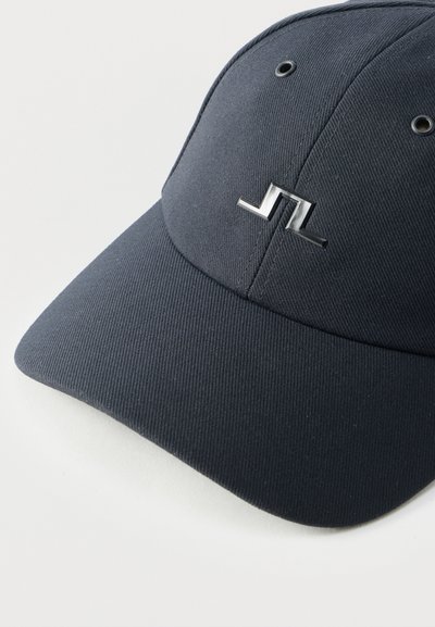 Μαύρο καπέλο τύπου μπέιζμπολ με μικρό ασημένιο γεωμετρικό έμβλημα στο μπροστινό μέρος, υφασμάτινη υφή και δύο οπές αερισμού ορατές.
