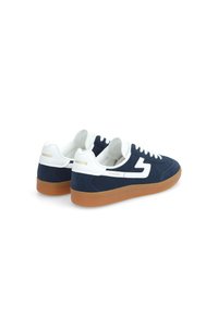 Baskets basses en daim bleu marine avec des accents et des lacets blancs, présentant une semelle en caoutchouc gomme et un détail de marque sur le talon.