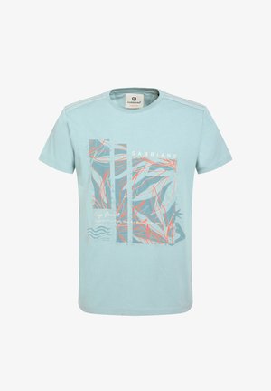 Gaiši zils kokvilnas T-krekls ar grafisku dizainu, kas ietver abstraktus lapu ornamentus jūras zaļā un korallkrāsā, īsām piedurknēm un apaļu kakla izgriezumu.