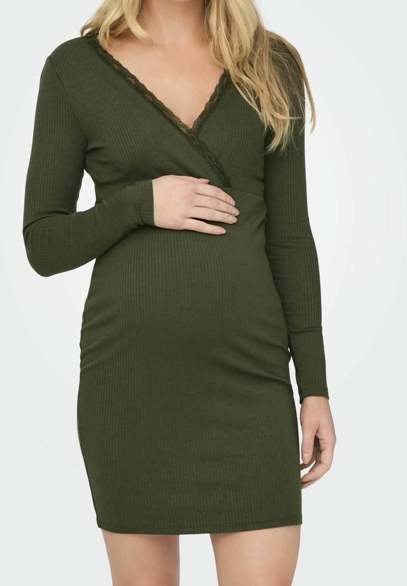 Mörkgrön ribbad klänning med långa ärmar, djup V-ringning och spetsdetaljer. Designad för komfort med en figurnära passform för en snygg look.