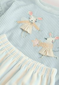 Embroidered blue cotton dress featuring two mice with wings; pleated light blue and cream skirt with subtle stripes and frilled waistband.
