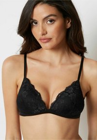 Bralette in pizzo nero con forma a coppa triangolare, spalline regolabili, orli smerlati e dettagli a motivo floreale su tutta la stoffa.
