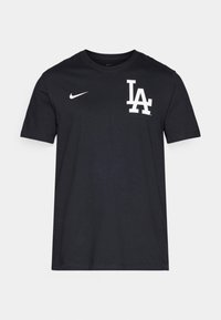 Black cotton t-shirt featuring a white "LA" logo and Nike swoosh on the left chest. Rounded neck, short sleeves, and a straight hem.