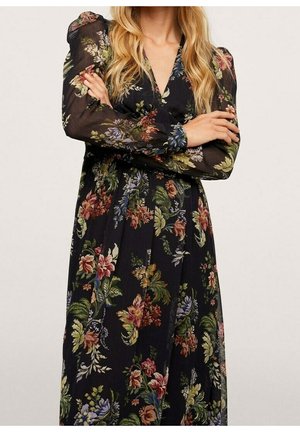 Robe noire à motifs floraux avec manches longues en tulle transparent et encolure en V. Le tissu présente un mélange vif de couleurs et des motifs floraux complexes.