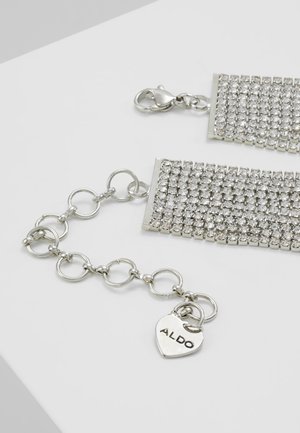 Bracelet ton argent avec strass scintillants, maillons réglables et un pendentif en forme de cœur gravé de "ALDO".