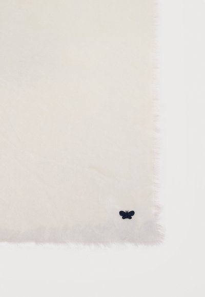 Ύφασμα κρεμ με φρατζόλες στις άκρες και ένα μικρό σκούρο μπλε πεταλούδα κεντημένη κοντά στην κάτω δεξιά γωνία.