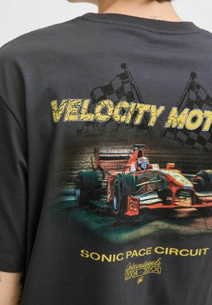 Black t-shirt featuring a graphic of a red racing car with "VELOCITY MOTOR" and "SONIC PACE CIRCUIT" text in yellow, distressed print.