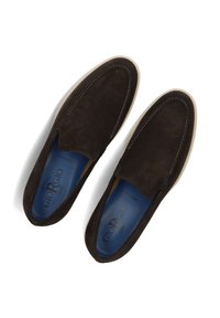 Bruine suede instappers met een ronde teen, contrasterende lichtgekleurde zool en een gevoerde binnenzool met blauwe en gele accenten.