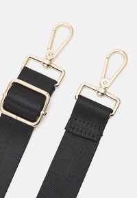 Sort nylonrem med guldfarvede metalclips og -beslag. Har et robust design med en struktureret overflade og en rektangulær spænde-detalje.