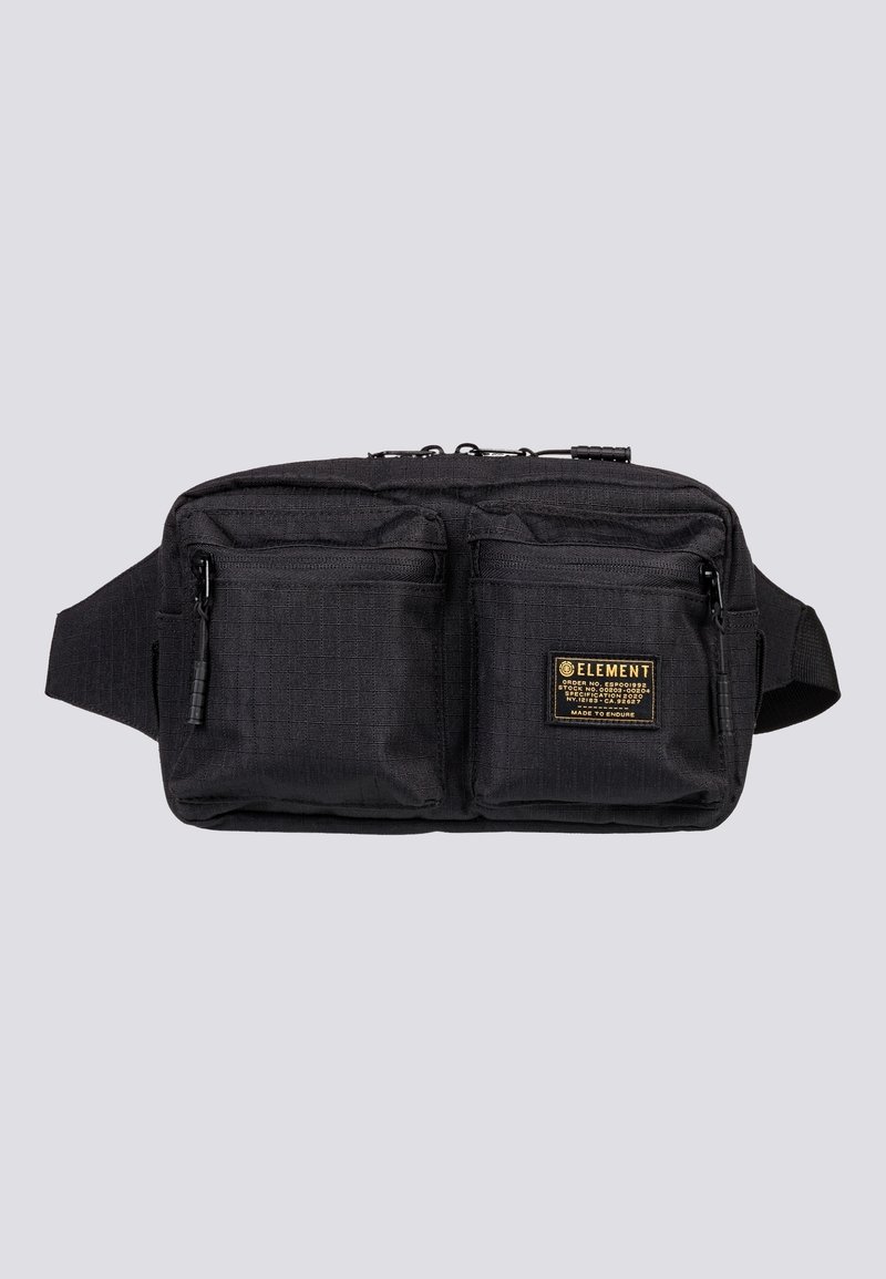 Sac banane noir avec deux poches avant zippées et un patch de marque sur la poche droite, sur fond gris clair.