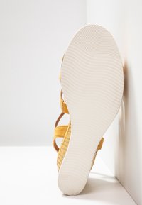 Sandale jaune avec une tige texturée, des brides solides et une semelle en caoutchouc blanche à motif. Taille indiquée : 37.