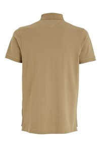 Μπεζ πόλο μπλουζάκι με κοντά μανίκια, γιακά, υφασμάτινη υφή και πλευρικές σχισμές στο τελείωμα για ευκολία κίνησης.