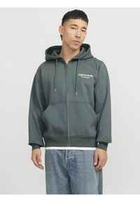 Sudadera gris con cremallera hecha de tela suave, con capucha ajustable, bolsillos frontales y un pequeño logotipo en el pecho.