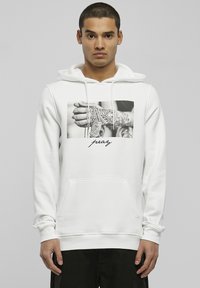 Weißer Hoodie mit einem schwarzen und weißen Grafikdruck auf der Vorderseite, der eine tätowierte Hand und Ketten zeigt, ausgestattet mit einer Kängurutasche und einer Kapuze mit Kordelzug.