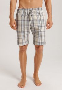 Pantalones cortos de cuadros en tonos beige, azul y gris, fabricados con un tejido ligero. Presentan una cintura elástica con cordón para un ajuste ajustable.