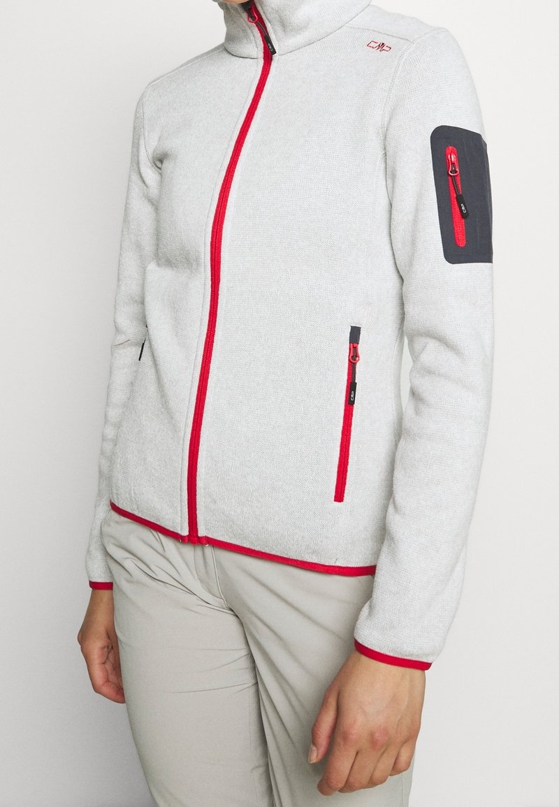 Giacca in fleece grigia chiara con zip rossa e dettagli in rosso. Presenta un colletto alto, tasche con zip e una toppa nera con dettagli rossi sulla manica.