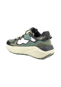 Scarpa sportiva con tomaia camouflage, dotata di pannelli in suede nero e verde, suola spessa color crema e accenti bianchi a contrasto nel design.