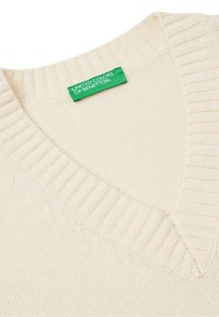 Krémový pletený svetr s výstřihem do V, žebrovaným lemem a zelenou etiketou United Colors of Benetton. Měkká textura, standardní střih.