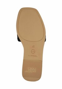 La suola della scarpa presenta un fondo in gomma beige testurizzata con un'impronta del logo, caratterizzando un design piatto e una punta arrotondata per il massimo comfort.