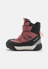 Pink and black winter boot with textured fabric and rubber sole. Features dual Velcro straps, gray midsole, and orange pull tab.
