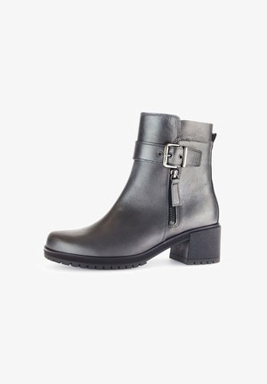 Black leather ankle boot with a square toe, side zipper, and buckle detail. Features a chunky heel and textured sole for traction.