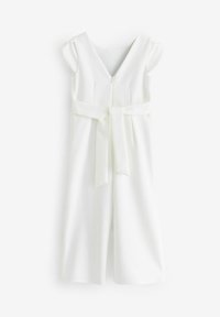 Combinaison blanche sans manches avec col en V, jambes larges et ceinture en tissu nouée à la taille, présentée sur un fond uni.