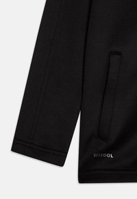 Casaco preto com uma textura suave, apresentando um bolso lateral, costuras cosidas e um discreto logótipo "BECOOL" perto da bainha.
