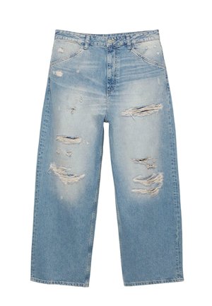 Svetlomodré roztrhané džínsové nohavice s širokými nohavicami, viacerými trhlinami na predných stehnách a vyblednutou rifľovinou.