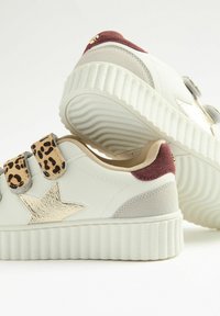 Witte sneakers met een gestructureerde platformzool, voorzien van een gouden sterdetail, leoppardprint banden en bordeauxrood suède accenten.