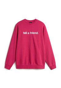 Sweat-shirt rose à col rond avec texte blanc « tell a friend. » centré sur le devant, manches longues et poignets et ourlet côtelés.