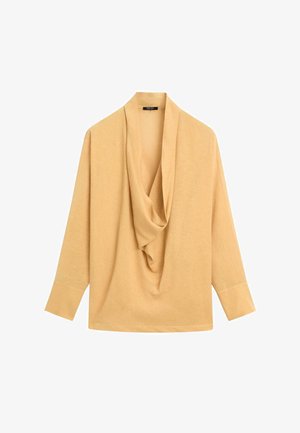 Blouse à manches longues couleur chameau avec encolure drapée en col bénitier et larges poignets, présentée sur un fond blanc.