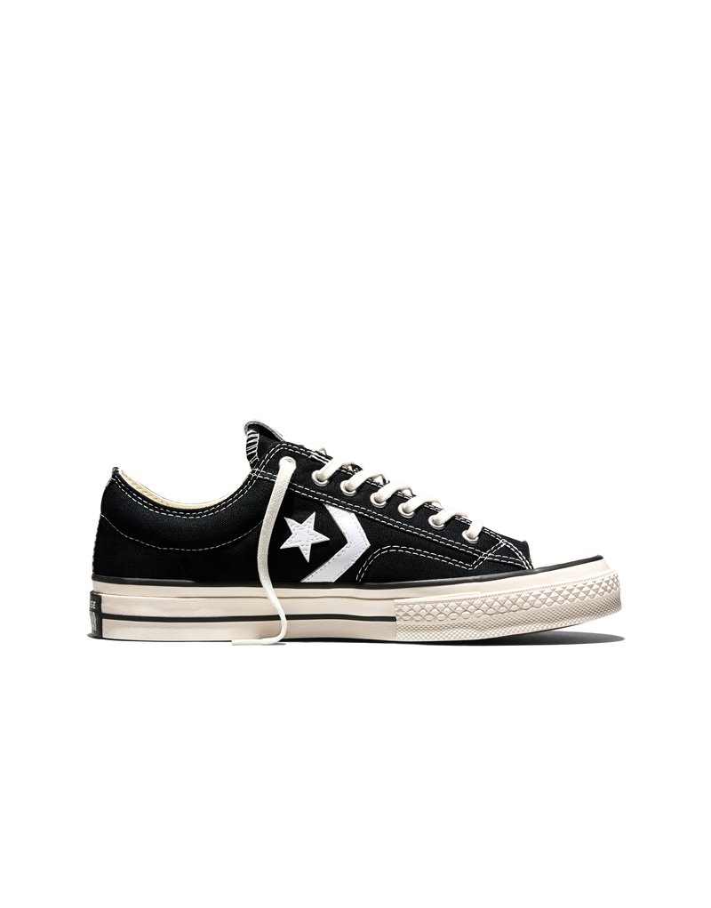 Schwarzer Converse Sneaker mit niedrigem Schaft, weißem Sternlogo, weißen Schnürsenkeln sowie off-white Gummisohle und Zehenkappe, seitlich auf weißem Hintergrund abgebildet.