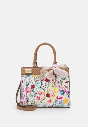 Håndtaske med brune håndtag og strop, hvid krop med farverigt blomsterprint og en lyserød og beige sløjfe bundet på det ene håndtag.