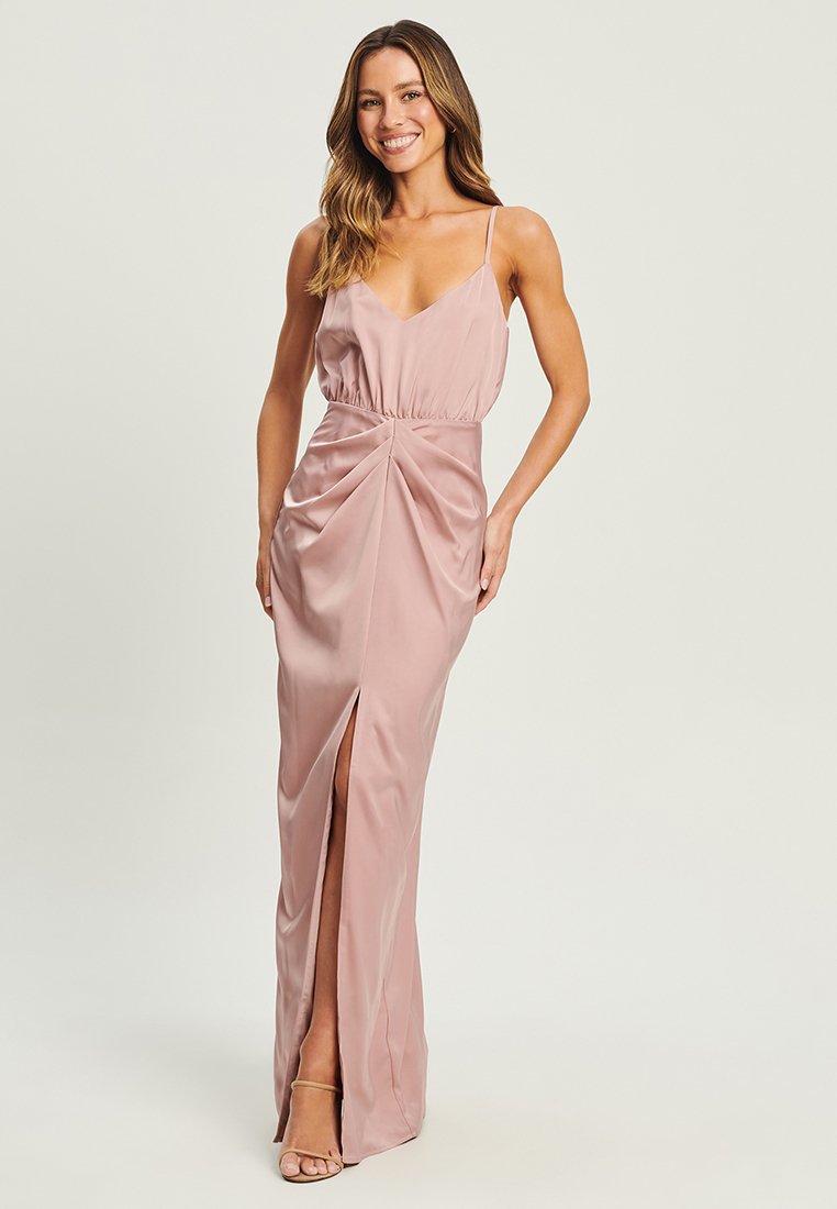 Long, light pink satin dress with spaghetti straps, gathered waist, and a thigh-high slit. Smooth texture with subtle draping details.