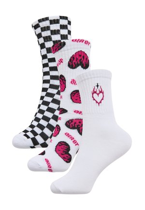 Tre paia di calzini alla caviglia: uno a scacchi bianco e nero, uno bianco con motivi a cuori rosa e uno bianco con un design a cuore e fiamme.