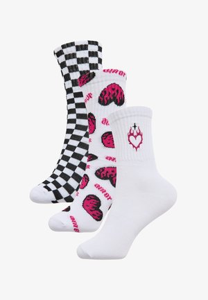 Tre paia di calzini alla caviglia: uno a scacchi bianco e nero, uno bianco con motivi a cuori rosa e uno bianco con un design a cuore e fiamme.