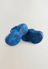 Zilas gumijas sandales ar teksturētu zoli, regulējamu siksnu un atvērtu dizainu, kurām ir gan vienkrāsas, gan gradienta toņu maisījums.