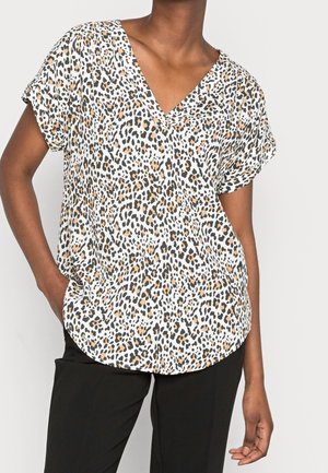 Blusa a maniche corte con scollatura a V in tessuto bianco con motivo leopardato caratterizzato da macchie nere, marroni e arancioni. Vestibilità ampia e orlo arrotondato.