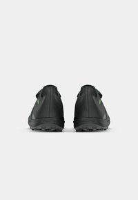 Black athletic shoes with a smooth texture, rubber soles, and green accents. Design features a lace-up closure and padded collar.