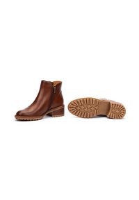 Brown leather ankle boots with a side zipper, featuring a textured brown rubber sole and a block heel. Smooth finish and minimal stitching.