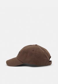 Brown cotton baseball cap with a curved brim, adjustable strap at the back, and logo detail on the front. Smooth texture.
