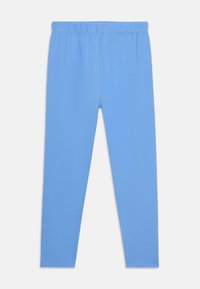 Lichtblauwe leggings van zachte stof, met een rekbare tailleband en een slim fit die taps toeloopt bij de enkels. Geen patronen of herkenbare accenten.