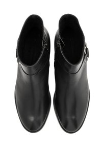 Une paire de bottes en cuir noir à mi-mollet avec des zippers latéraux et des boucles, vues d'en haut sur un fond blanc.