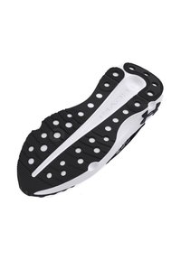 Black and white athletic shoe sole featuring circular cutouts, textured grip patterns, and a curved design for flexibility.