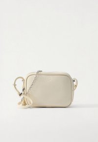 Liten beige rektangulär axelremsväska i läder med silverkedja och justerbar rem på vit bakgrund.